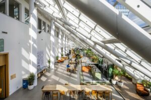 Moderne en lichte gemeenschappelijke ruimte aan de Johan Huizingalaan met grote ramen, zitplekken en een bar.